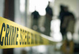 Crime,scene,tape,with,blurred,forensic,law,enforcement,background,in